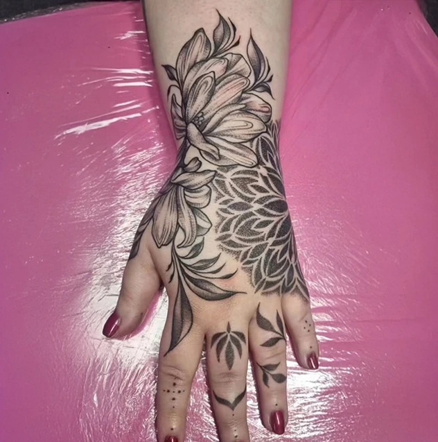 Hand coverup tattoo in ornamental style with leaves and plants growing up the arm